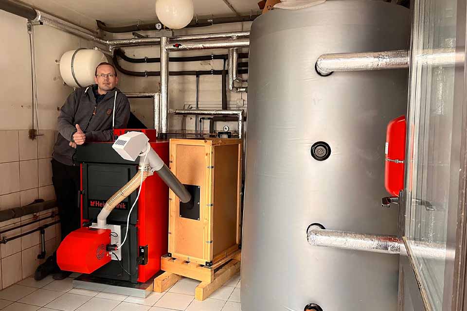 zufriedener Kunden einer Pelletheizung mit Vorratsbehälter und installiertem Pufferspeicher